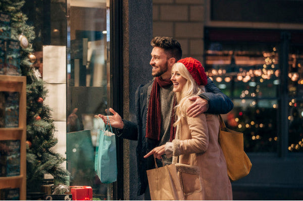 Paar beim Weihnachtsshopping vor Schaufenster