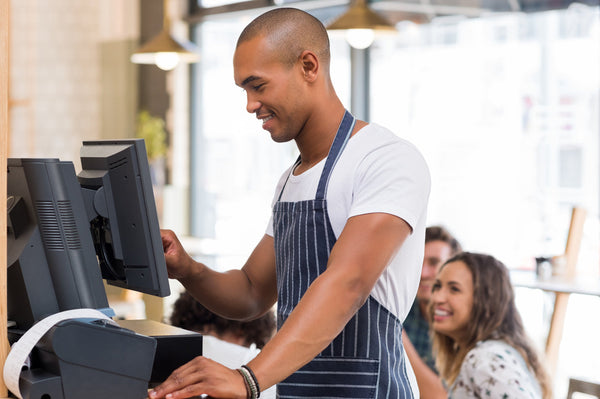Young waiter doing bill